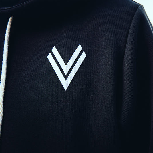 Nahaufnahme des ASK Voitsberg 3D-Wappens in weiß auf einem schwarzen Pullover