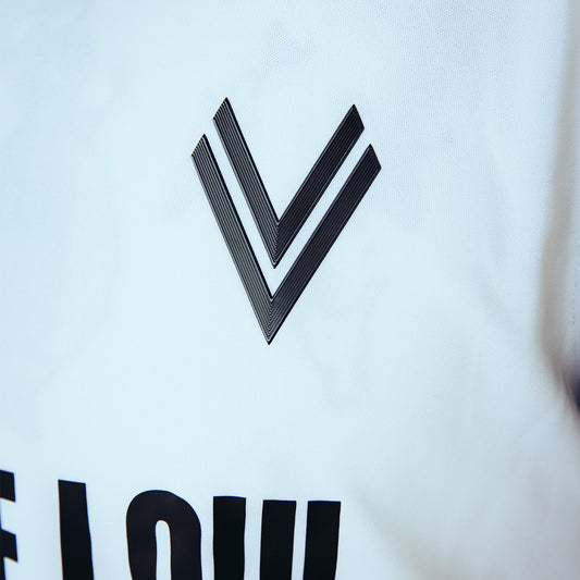 Detailansicht des schwarzen ASK Voitsberg 3D-Wappen auf weißem Trikot.