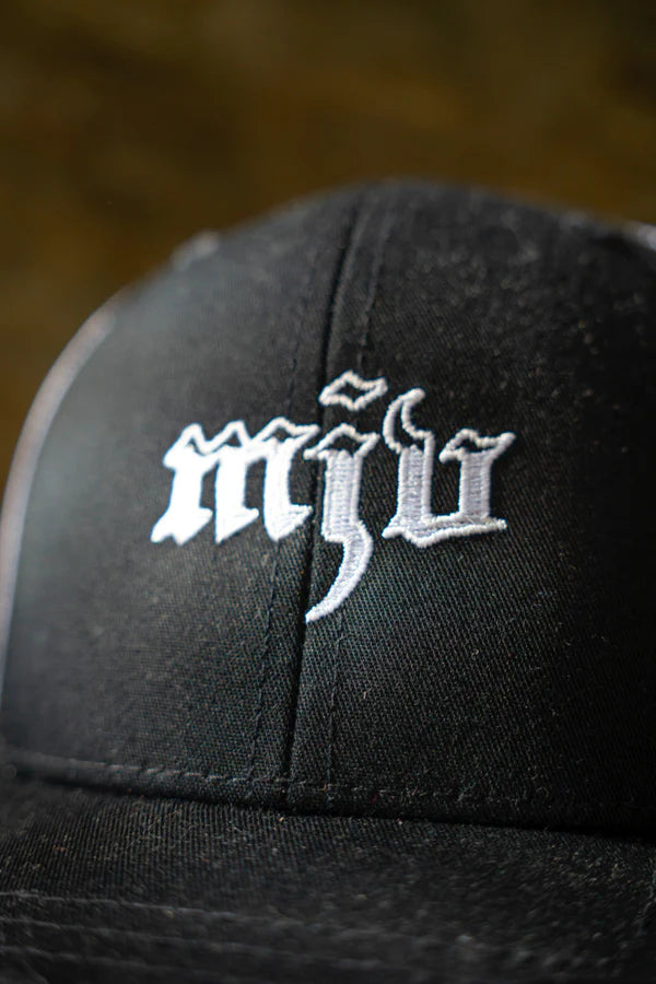 Nahaufnahme des schwarz-weißen Trucker-Caps mit gesticktem 'MJV' Logo.